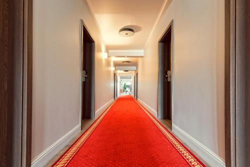 a corridor with a red carpet in a hallway at Maestro Inn in Krasnystaw