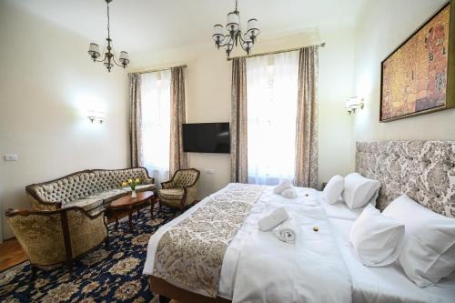 a hotel room with a large white bed and a chair at Casa ABA in Sibiu