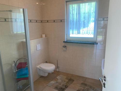 e bagno con servizi igienici, finestra e doccia. di Bungalow in Werder am Glindower See a Werder