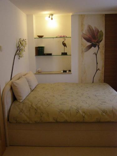 a bedroom with a bed with a flower on the wall at Ferienwohnung "Am Geiseltal" in Merseburg