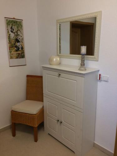 a white dresser with a mirror and a stool at Ferienwohnung "Am Geiseltal" in Merseburg
