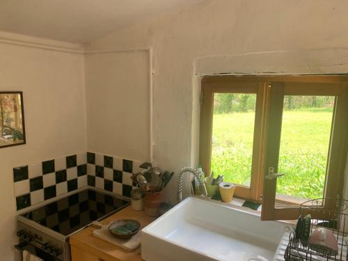 a kitchen with a large white sink and a window at Mymoustiers in Moustiers-Sainte-Marie