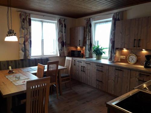 a kitchen with a table and a table and chairs at Biobauernhof und Ferienhaus Riederbauer in Rettenschöss
