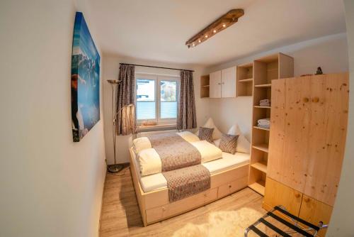 a small bedroom with a bed and a window at Haus Erli in Mittenwald