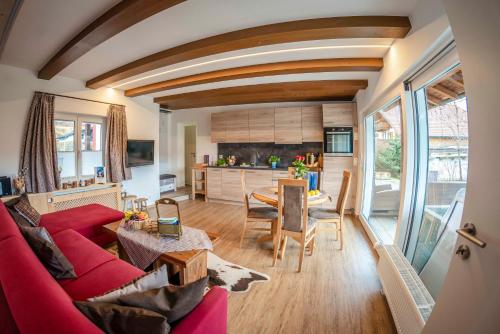 a living room with a red couch and a table at Haus Erli in Mittenwald