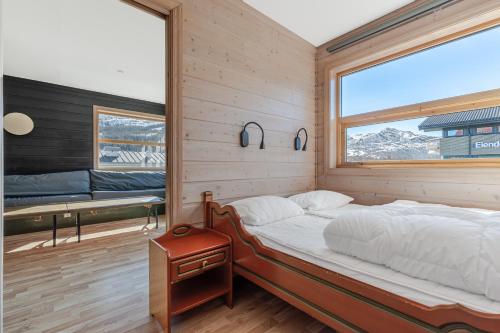 1 dormitorio con cama y ventana grande en Skiers Lodge 2 - Saga Apartments, en Hemsedal