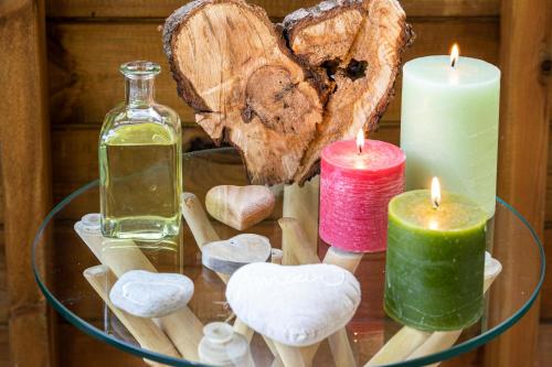 a glass table with candles and a heart and a bottle at Gîtes Domaine des Machottes in Grans
