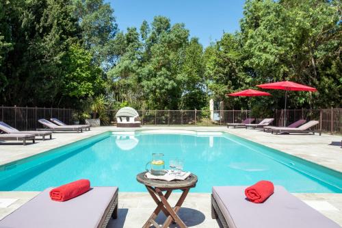 a swimming pool with chairs and a table next to it at Gîtes Domaine des Machottes in Grans