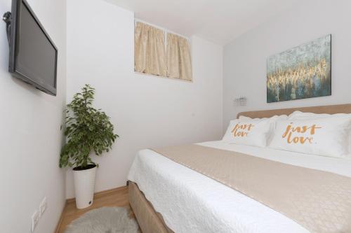 1 dormitorio con 1 cama y TV de pantalla plana en Long Apartment en Makarska