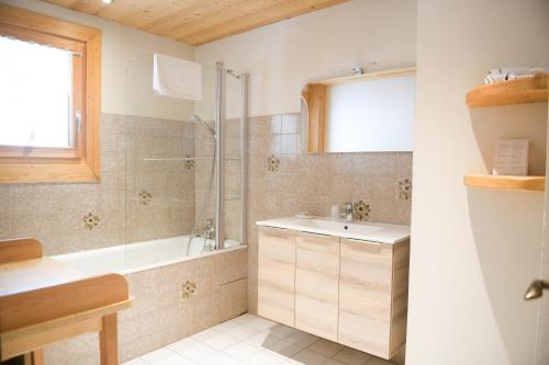 ein Bad mit einer Badewanne, einem Waschbecken und einer Dusche in der Unterkunft Le Dahu in Chamonix-Mont-Blanc
