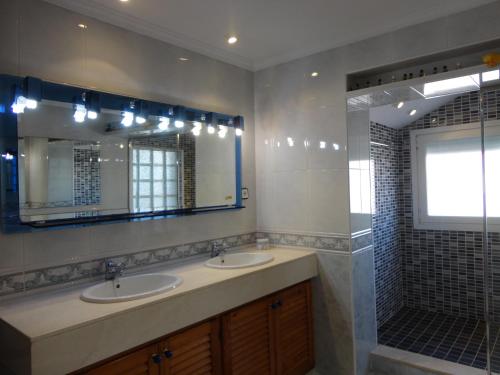 uma casa de banho com 2 lavatórios e um chuveiro em Villa cecilia em Sant Feliu de Guíxols