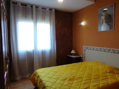 um quarto com uma cama amarela e uma janela em Villa cecilia em Sant Feliu de Guíxols
