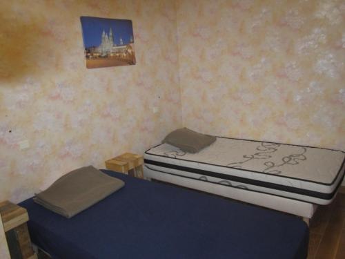 2 camas individuales en una habitación con una foto en la pared en Gîte La Bastide, en Tournon-dʼAgenais