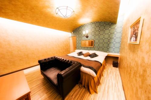 a bedroom with a bed and a leather couch at Kumamoto Hotel Christmas Forest Garden (Love Hotel) in Shimo-koga