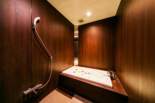 a bathroom with a bath tub in a wooden wall at Kumamoto Hotel Christmas Forest Garden (Love Hotel) in Shimo-koga