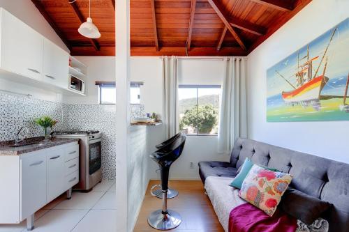 a living room with a couch and a kitchen at Loft na Lagoa da Conceição in Florianópolis