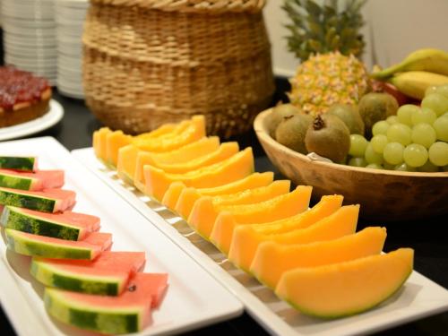 a table topped with plates of fruit on plates at Hotel Purvita by Oberlechner in Maranza