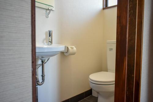 a bathroom with a toilet and a sink at Panketo Lodge & Yoga Studio in Hakuba