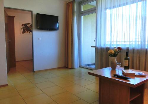 a room with a table with a vase of flowers on it at KARL Haus KMB Seeappartement am Ossiacher See mit direktem Seezugang, Hallenbad in Bodensdorf