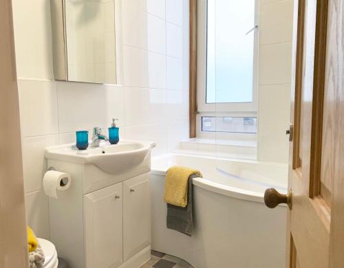 a bathroom with a sink and a tub and a toilet at Forest Park Apartment in Dundee