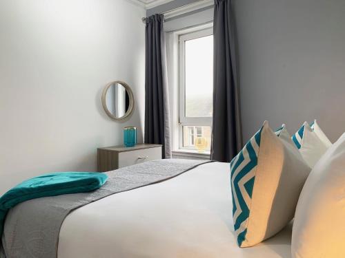 una camera da letto con un grande letto e una finestra di Forest Park Apartment a Dundee