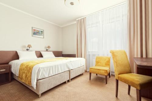 um quarto com uma cama, uma secretária e uma cadeira em Maestro Inn em Krasnystaw