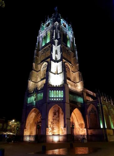 a large building with a tower at night at Le petit béguinage in Tongeren