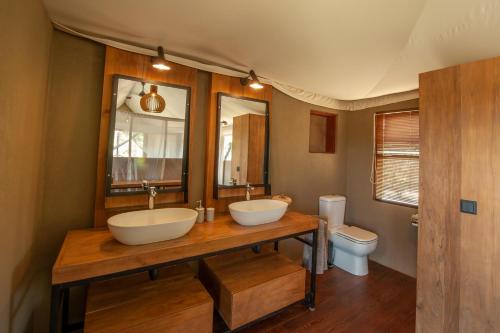 a bathroom with two sinks and a toilet at Chikunto Safari Lodge in Kakumbi