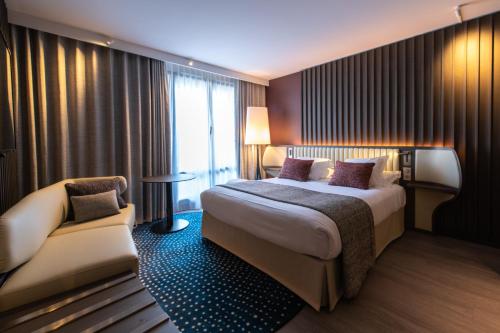 a hotel room with a bed and a chair at Best Western Premier Hotel de la Paix in Reims