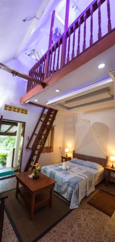 a bedroom with a bed in a room with a staircase at AABANA Beach & Watersport Resort in Malapascua Island