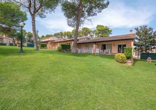 a house with a green yard with a house at Village Golf Beach in Pals