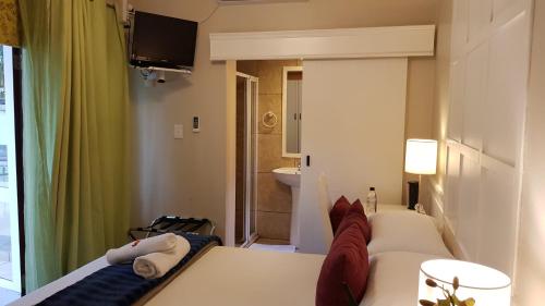 a hotel room with a bed and a bathroom at Villa Lugano Guesthouse in Johannesburg