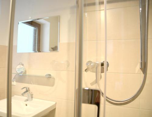 a bathroom with a shower and a sink at Pension Almhof Baumgarten in Bad Reichenhall