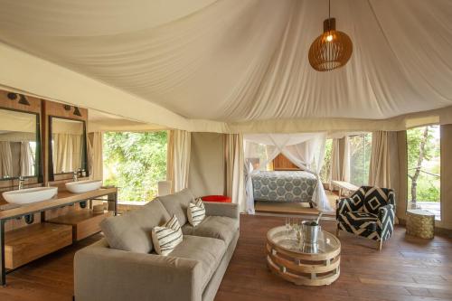 a living room with a couch and a table at Chikunto Safari Lodge in Kakumbi