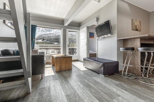 a living room with a couch and a television in a room at Hemsedal Cafe Skiers Lodge in Hemsedal