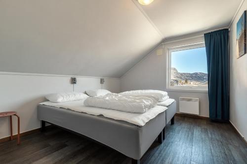 Bett in einem Zimmer mit einem großen Fenster in der Unterkunft Hemsedal Cafe Skiers Lodge in Hemsedal