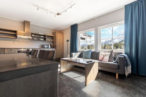 a kitchen and living room with a couch and a table at Hemsedal Cafe Skiers Lodge in Hemsedal