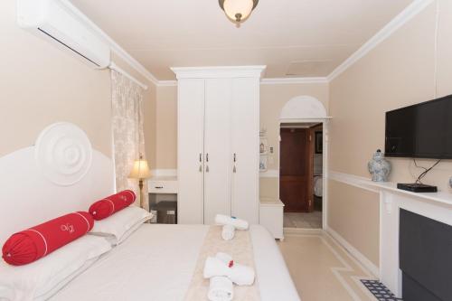 a room with a bed with red pillows on it at Villa Lugano Guesthouse in Johannesburg