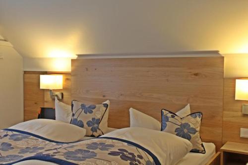 a bedroom with a bed with blue and white pillows at Hotel Falkenseer Hof in Falkensee