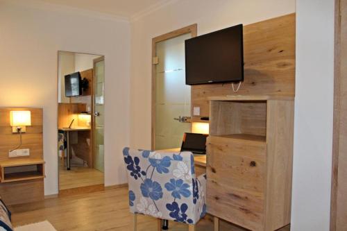 Zimmer mit einem Schreibtisch und einem TV an der Wand in der Unterkunft Hotel Falkenseer Hof in Falkensee