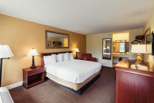 a hotel room with a bed and a desk with two lamps at Calloway Inn and Suites in Hammond