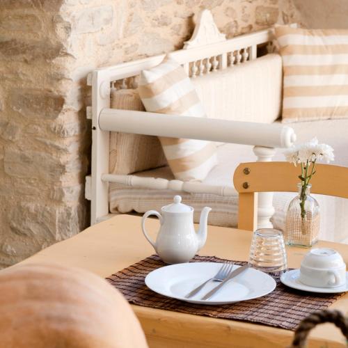 a table with a plate and a tea set on it at Yialos Ios Hotel in Ios Chora