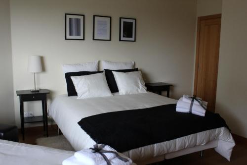 a bedroom with a large bed with black and white pillows at Quinta Porto dos Lobos in Sever do Vouga