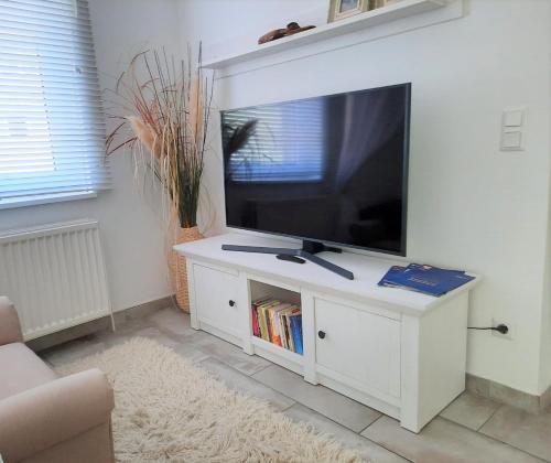 un soggiorno con TV su un centro di intrattenimento bianco di HOLI DAY SPA Appartement 2 a Berlino