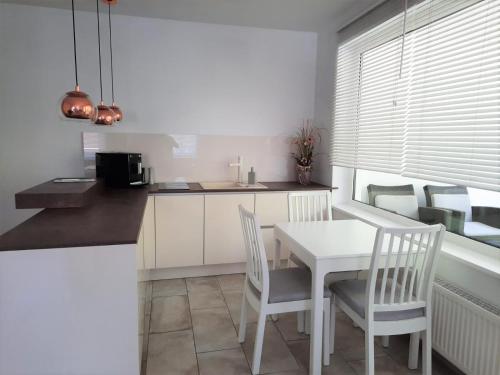 eine Küche mit einem weißen Tisch und Stühlen sowie ein Esszimmer in der Unterkunft HOLI DAY SPA Appartement 2 in Berlin