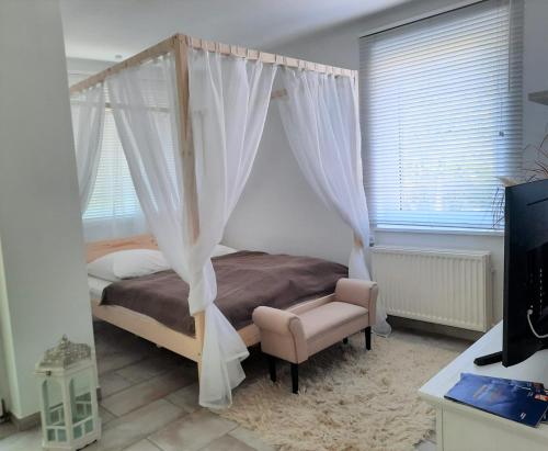 a bedroom with a canopy bed and a chair at HOLI DAY SPA Appartement 2 in Berlin