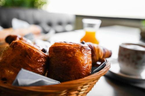 una cesta de pan y bollería en una mesa en Hostellerie LE PANEL, en Mandelieu-la-Napoule