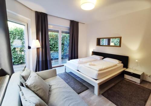 a bedroom with two beds and a couch at spacious studio - city centre - airconditioned - netflix - terrace in Heidelberg