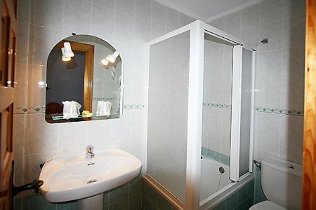 a bathroom with a sink and a toilet and a mirror at Hotel Rural el Arco in Pesquera de Ebro