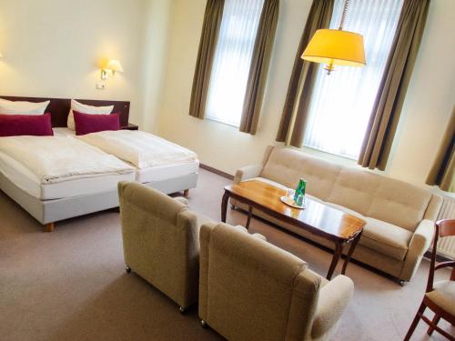 a hotel room with a bed and a couch and a table at Hotel Bürgerhof Wetzlar in Wetzlar